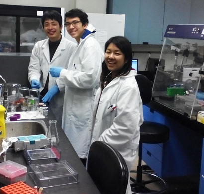 Three smiling students surrounded by laboratory equipment in Berman Lab.