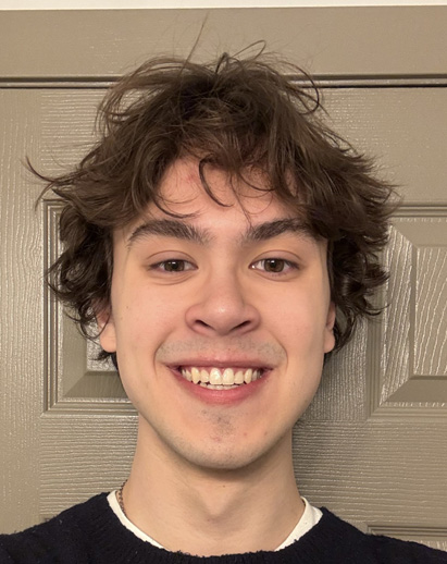 A photo of Alex. He is a young white man and is smiling.